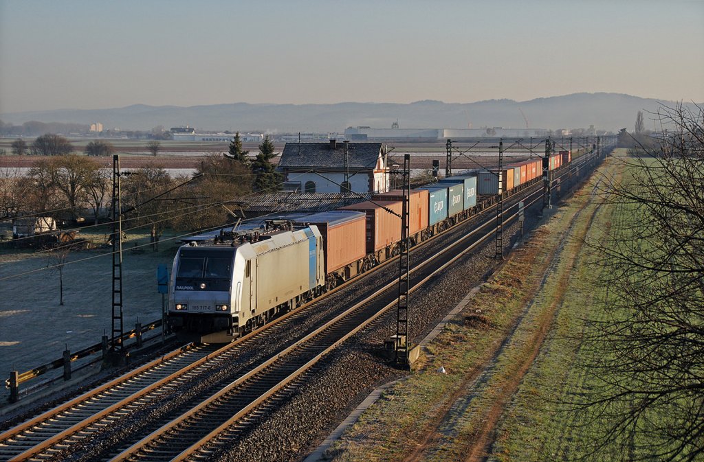 Die Sonne ist gerade aufgegangen, als 185 717-6 mit dem BoxXpress DGS 69291 Hamburg-Waltershof - Mannheim Hgbf bei Ladenburg nur noch wenige Kilometer bis zum Ziel vor sich hat. 20.03.12