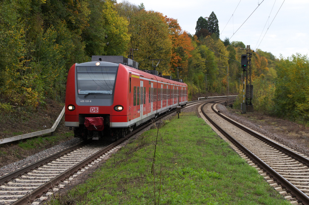 Die Sonne verstecke sich hinter einem Schleier, daher gab es aber auch keine Schatten, die sich negativ auf das Photo auswirken konnten.

425 133-6 ist als RB 71 von Homburg/Saar nach Trier unterwegs.
Der Triebzug hat hier beim Hp Fremersdorf schon den durch Industrie geprgten Abschnitt des Saartals zwischen Saarbrcken und Dillingen verlassen und befindet sich jetzt im lndlichen Kreis Merzig-Wadern.

Der Ort Fremersdorf auf der anderen Saarseite gehrt seit der Gebietsreform 1974 zum Landkreis Saarlouis und zur Gemeinde Rehlingen-Siersburg. Der Haltepunkt, durch eine Fugngerbrcke ber die Saar, die B51 und die A 8 verbunden, liegt im Kreis MZG.

19.10.2012 - KBS 685 - Bahnstrecke 3230 Saarbrcken - Karthaus