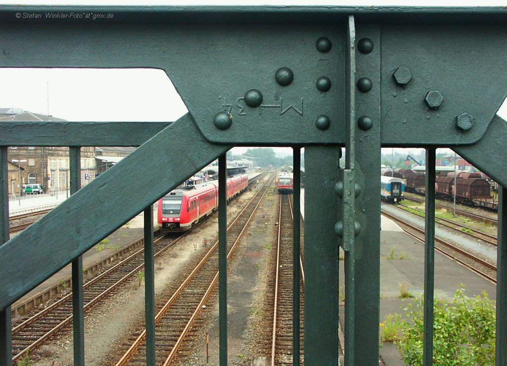 Die Tage der alten  Luftbr�cke  des Steges �ber den ganzen Bahnhof Hof Hbf sind gez�hlt. Ein kompletter Neubau f�r einige Mio E soll her, vor allem auch wegen der Elektrifzierung. Hier ein Blick auf Details wie Neitverbindungen und den kopfstehenden Schriftzug MH also Maxh�tte zusammen mit einem Blick auf das was es in Hof Zugtechnisch gibt: 612er, 628, den ALEX und ganz rechts G�terverkehr... Ob die neue Br�cke Ausblick zul�sst weiss noch keiner....