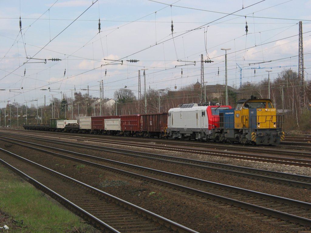 Die V 157 der TWE (G1205 von Vossloh) bringt am 25. Mrz 2010 den fertigen Zug mit E 37 531 der Captrain (Prima 2 von Alstom) in Dsseldorf Rath aus dem Anschlu der Vallourec & Mannesmann Rhrenwerk unter Fahrdrath.
