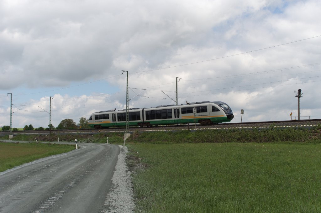 Die Vogtlandbahn auf dem Weg nach Hof - Am 23 Mai 2013, ein paar Tage vor dem groen Regen, war Desiro VT 25 der Vogtlandbahn von Zwickau nach Hof unterwegs.
Hier bei Reuth wird der Scheitelpunkt der Strecke erreicht.
Da durch die Bauarbeiten fr die Elektrifizierung viele Brcken erneuert werden mssen, hier bei Reuth gleich zwei, mssen die Autofahrer im Vogtland viele Umleitungen in Kauf nehmen.
In Reuth hat man eine Behelfsumfahrung angelegt, die ehemals ein Feldweg war und unter der Bahn hindurch fhrt, um die Anwohner vor riesigen Mehrkilometern zu bewahren.
Bahnstrecke 6362 Leipzig - Hof.