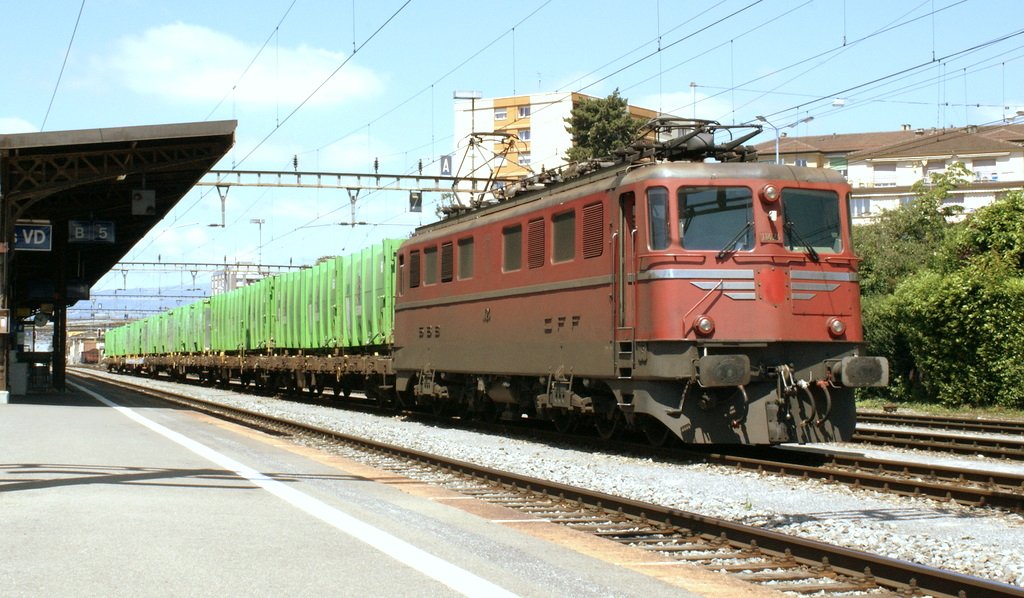 Die Wappenlose Kantonslok Ae 6/6 11424 mit eine Tridel-Güterzug am 4. Juni 2010 in Renens VD.