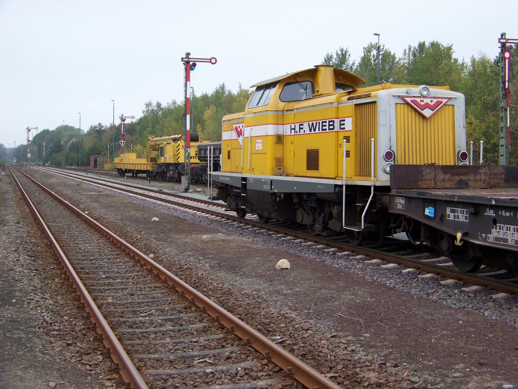 Die Wiebe 212 192-9 muss warten da gerade Gleise vom Zug abgeladen werden. Im Hintergrund sieht man den abgestellten Kranzug. (07.10.10)