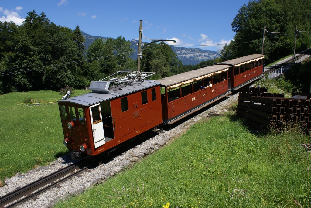 Die wieder in den Ursprungszustand versetzte He 2/2 14 bremst ihren Zug am 9.8.10 talwrts. Das Bild entstand oberhalb von Wilderswil.