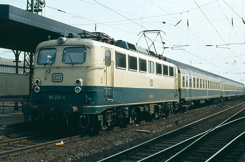 Dieser Diascan zeigt die 110 227-6 mit einem D-Zug in Richtung K�ln bei einem Zwischenhalt im Bahnhof Unna. Die Aufnahme entstand 1981. 