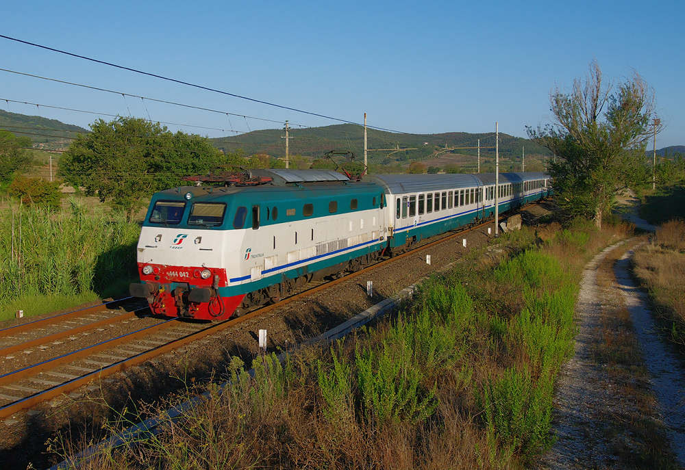 Dieses Bild zeigt die  Schildkrte  E 444 042 vor dem IC 501 auf dem Weg Sestri Levante nach Napoli Centrale. Aufgenommen wurde der Zug am Fue des Colline Metallifere dem Toskanischen Erzgebirge nahe der ehemaligen Bergbaustadt Gavorrano.