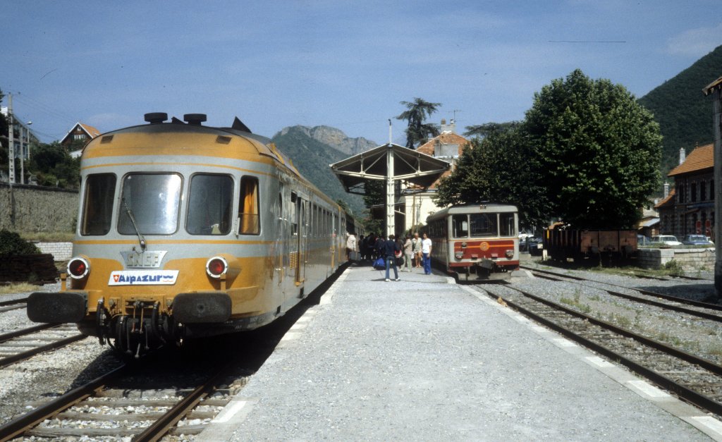 Digne im Juli 1982: Ein Triebzug der SNCF (Normalspur) und ein Aurorail / Schienenbustriebwagen der Chemins de fer de Provence (Meterspur) halten im SNCF-Bahnhof Digne. - In den Jahren 1981 bis 1989 gab es die Alpazur, eine Zusammenarbeit zwischen der SNCF und den Chemins de fer de Provence, die den Fahrgästen eine schnellere Verbindung zwischen Genève / Genf und Nice / Nizza ermöglichte, als wenn sie über Marseille hätten fahren müssen. - Im Jahre 1989 stellte die SNCF die Bahnbedienung auf der Strecke Saint-Auban - Digne ein, und seit diesem Jahr gibt es die kürzere und schnellere Reisevariante nicht mehr. - Auf der CP-Strecke Digne - Nizza, bietet  le Train des Pignes , d.h.  der Pinienzapfenzug , heute dem Reisenden eine schöne Fahrt von mehr als 3 Stunden mit 16 Viadukten, 15 Brücken und 25 Tunneln an.