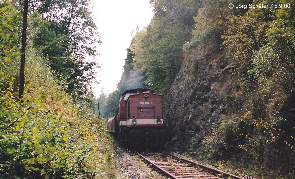 Direkt an den Bahnsteig des Haltepunkts Harra Nord schliet sich der 221 m lange Totenfelstunnel an: 204 612 wurde am 15.9.00 vor dem Sdportal mit einem Gterzug nach Saalfeld fotografiert.