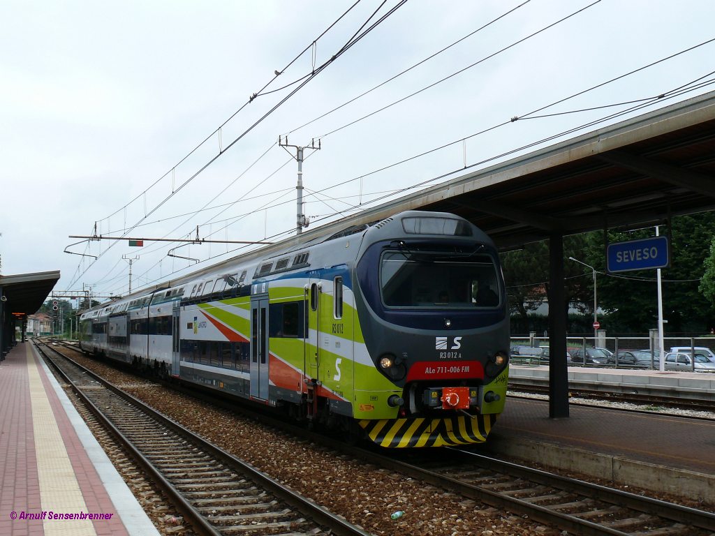 Doppelstockzug ALe711 006-FM+ALe711 008-FM vom Typ TSR(Treno Servizio Regionale). Er wird von LeNORD -dem Zusammenschluss der Nahverkehrssparten von FNM und FS in der Lombardei- eingesetzt. Dieser Zug geh�rt der FNM. Er tr�gt neben der Reihenbezeichnung ALe 711 nach FS-Norm auch noch die Reihenbezeichnung EB711 nach FNM-Art. 


Seveso 2012-06-04 

