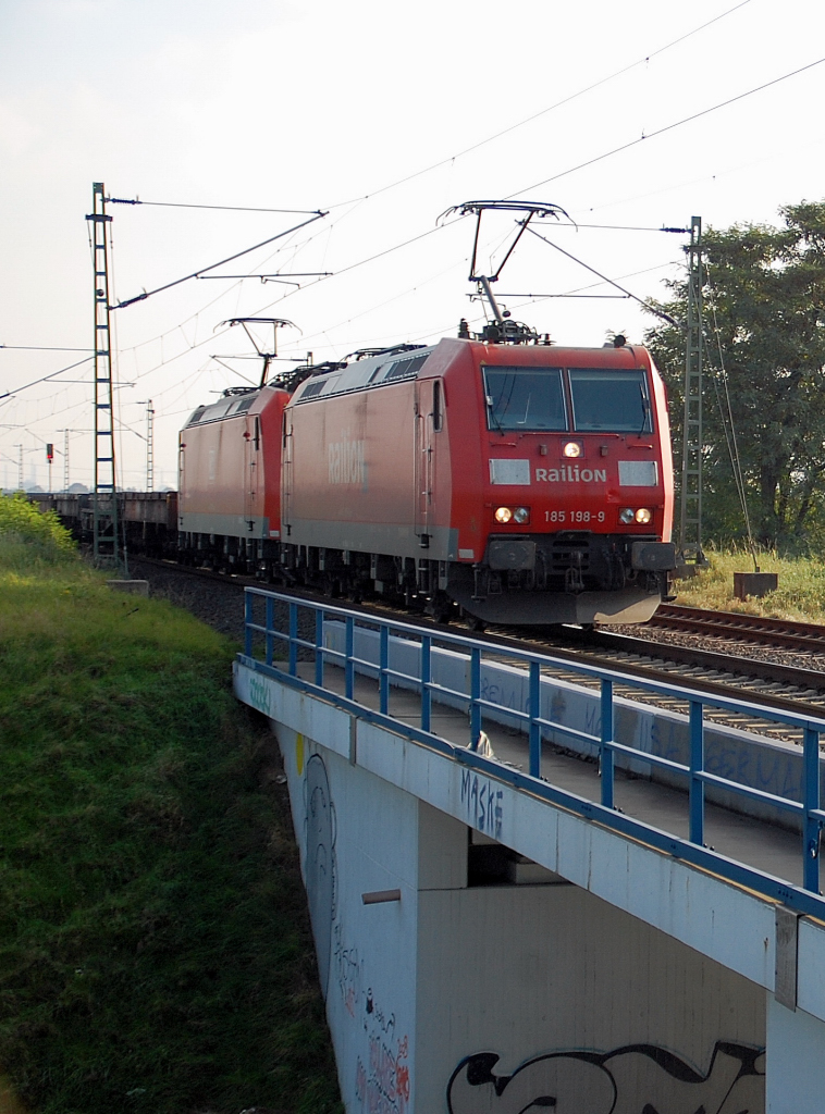 Doppeltracktion aus 185 198-9 und 185 138-5 nebst einem Leerzug Coiltragwagen. Fotografiert am 18.10.2010 bei Allerheiligen.