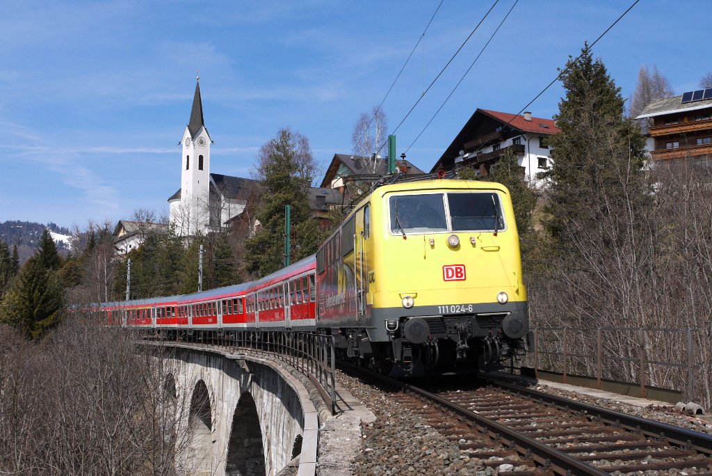 Drei Tage vor der vorbergehenden Einstellung des direkten Regionalzugverkehrs Mnchen - Innsbruck, gelang es mir die ADAC-Werbelok 111 024 vor dem bekannten Kirchenmotiv in Reith mit dem REX 5417 (Mnchen Hbf - Innsbruck Hbf) aufzunehmen.