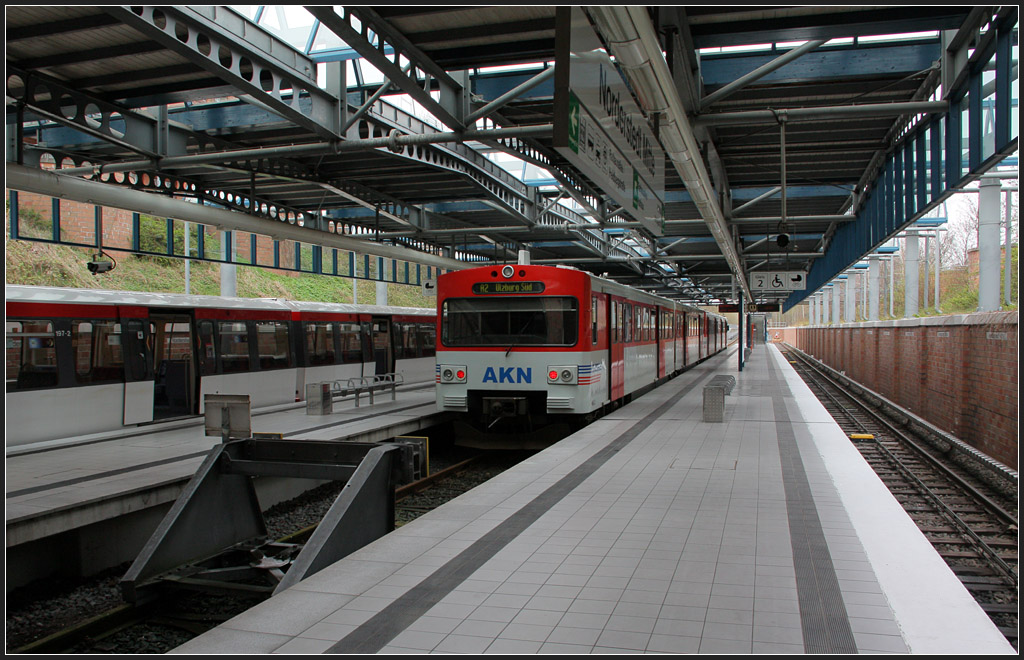 Dreigleisig - 

Die Umsteigestation  Norderstedt Mitte  für U-Bahn und AKN-Vorortbahn wurde am 28.09.1996 fertiggestellt. Das Hamburg U-Bahnnetz erreichte damit eine Streckenlänge von 100 Kilometer. Mit Verlängerung der der U1 wurde die AKN-Strecke entsprechend verkürzt. Vorher wurde am Bahnhof  Garstedt  von der U-Bahn in die AKN A2 umgestiegen. 

11.04.2012 (M)