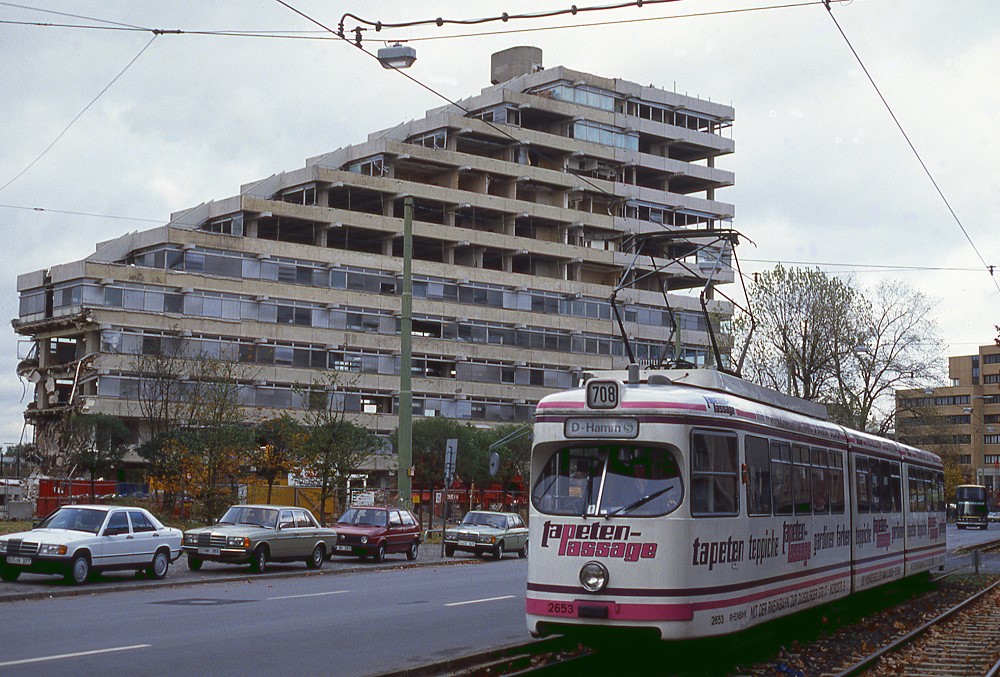 Dsseldorf Tw 2653 verlsst die Schleife Mrsenbroich via Brehmstrae, im Hintergrund das zu schleifende ehemalig Arag-Haus, 04.11.1989.