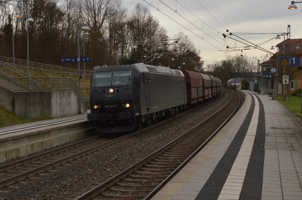 Durch Binau kommt am Mittag des 31.12.2012 die MRCE 185 547-7 mit einem Selbstentladewagenleerzug in Richtung Heidelberg gefahren, nach dem sie vorher die RE nach Mannheim in Neckarelz passieren lassen musste.