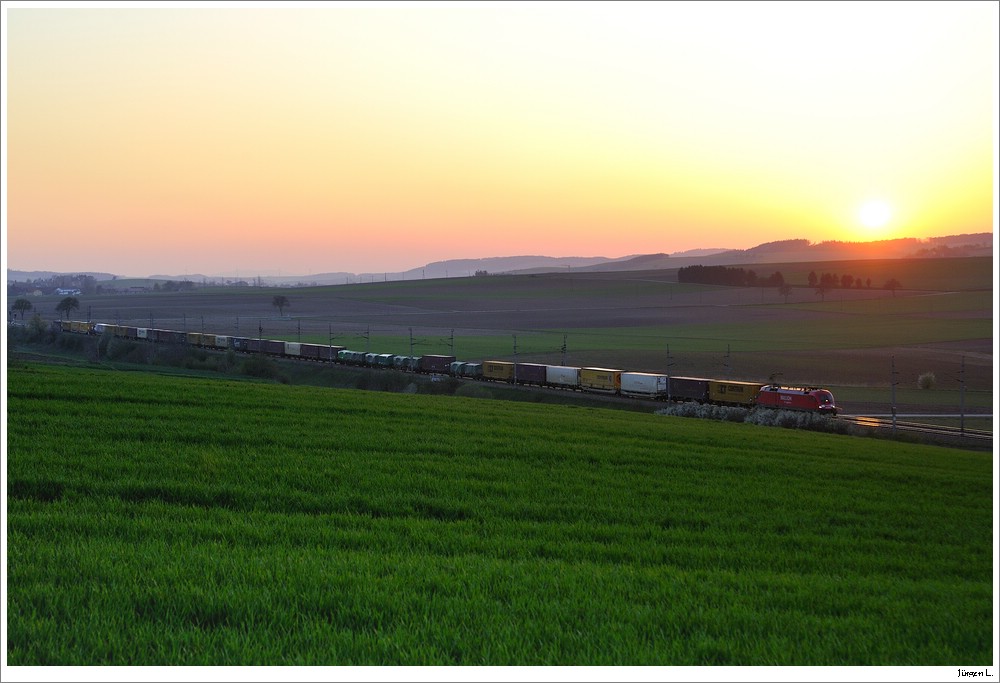 Durch die derzeit herumfliegende Vulkanasche wird das Licht stark gestreut, was eine deutliche rotfrbung des Abendlichtes mit sich bringt. Hier eine BR182 der Railion bei Ollersbach in Fahrtrichtung Osten; 17.4.2010.