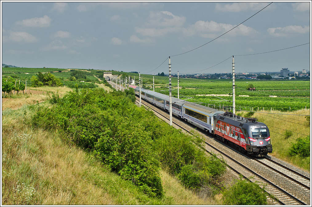 Durch die Weingrten von Pfaffsttten bringt 1116 138  Heeressport  den EC 103 POLONIA nach Villach, schon erwartet von einer Gruppe Fotografen beim Wchterhaus am Busserltunnel (erkennbar an den Warnwesten). LG an die Kollegen!
Pfaffsttten, 4.7.2012