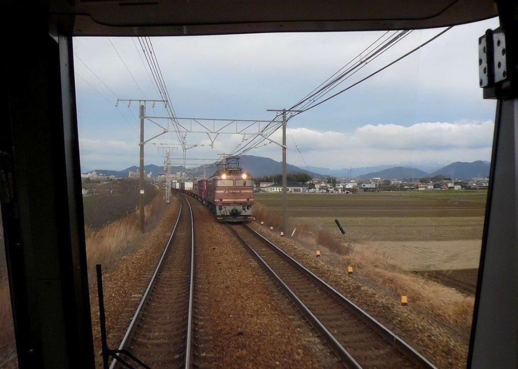 EF81: An einem stürmischen Abend kommt EF81 126 mit einem schweren Güterzug vom Japanischen Meer her entgegen. Aufnahme durch die verglaste Führerstandrückwand eines Gegenzugs, bei Shinohara am Biwa-See, 17.Februar 2010. 