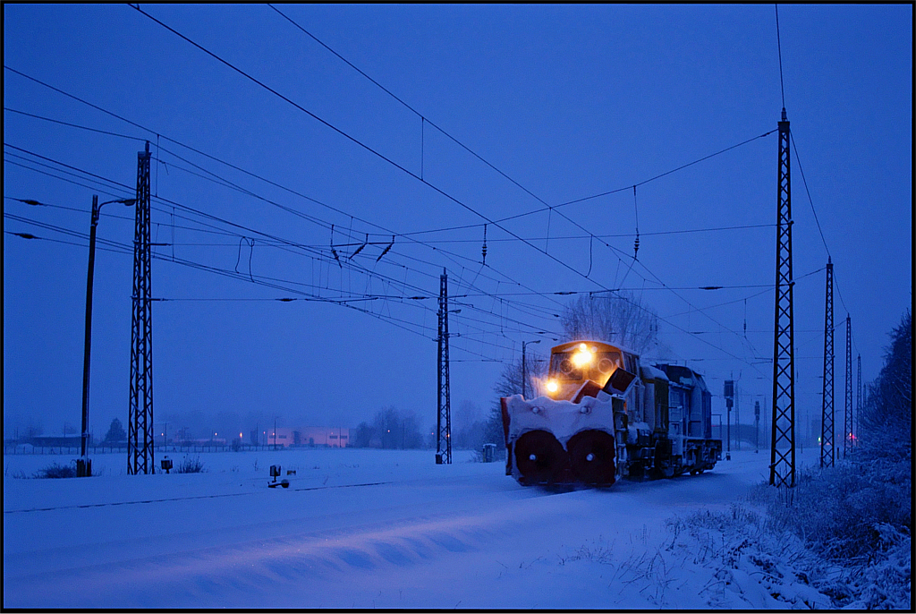 Eigentlich war dieser Fototag schon gedanklich abgeschlossen. Nach stundenlangem vergeblichen Warten auf eine Rumfahrt am Hp Miltzow wurden am 11.01.2010 noch einige Aufnahmen vom bereits 2 Tage zuvor zwischen Jeeser und Miltzow in eine Schneewehe gefahrenem und dabei teilweise entgleistem UBB-Doppel angefertigt. Auf der Rckfahrt von dort nach Miltzow machte sich aber bei meinen Mitstreitern und mir pltzlich Unruhe breit, denn in der Ferne waren Spitzenlichter zu sehen - also Fu aufs Gas und ber einen verschneiten Feldweg schnell zum nchsten Bahnbergang. Dort gelang dann schlielich 30 Minuten nach Sonnenuntergang noch diese Aufnahme der bereits in Richtung der UBB-Triebwagen fahrenden Rumeinheit.