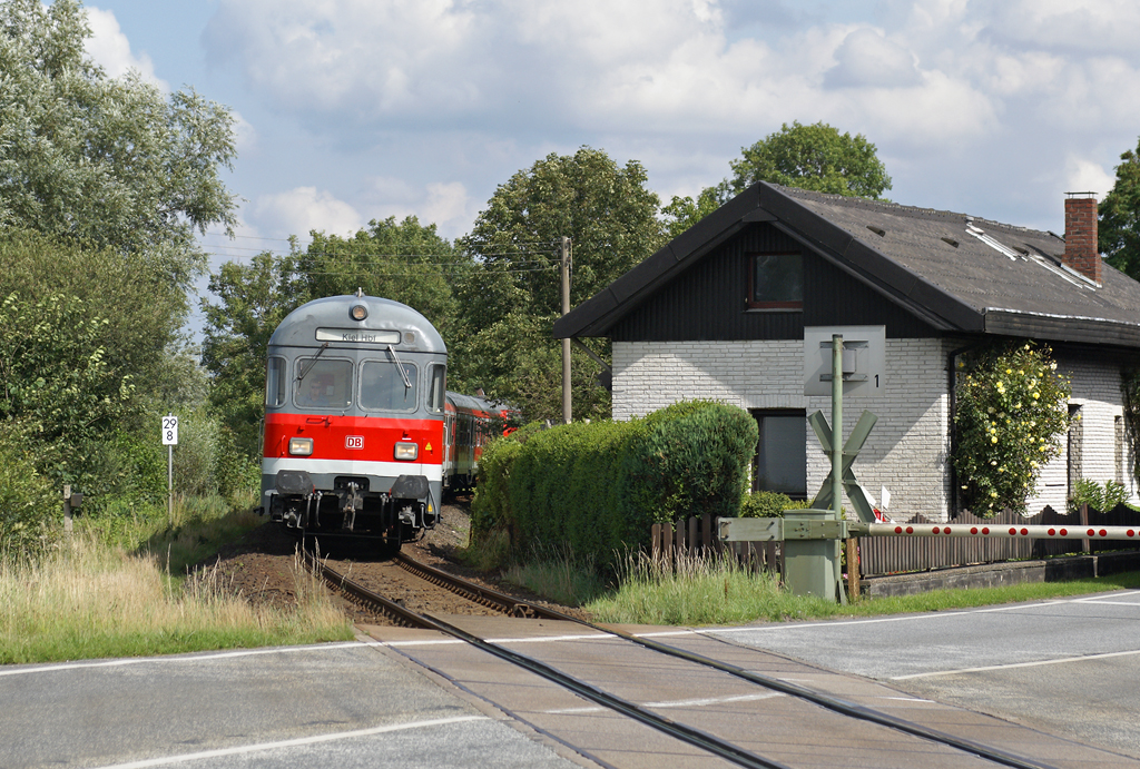 Ein von 218 453-9 geschobener RE nach Kiel Hbf passiert am 31.07.2009 den Bahnbergang Drnick zwischen Pln und Ascheberg.