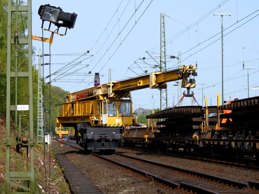 Ein 50to Kran der Firma Schweerbau verld am 17.04.2011 in Aachen West 15m lange Gleisjoche auf einen Bauzug. Hinter dem Kran trennt ein Team die Schienen mit einem Brenner am Schienenfu und Steg. Der Schienenkopf bleibt intakt, weil der Kran zum beladen noch der das Gleis fahren mu. Die Schienenkpfe werden mit einem Zweiwegebagger, der am Gleisende im Schotter steht gebrochen, indem er das Joch aus dem Schotter hebt. 