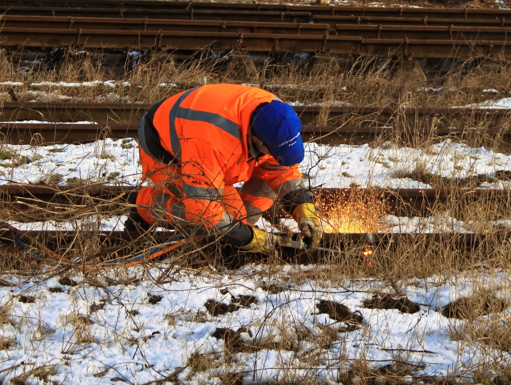 Ein Arbeiter der Firma Hering Gleisbau Gmbh trennt am 20.02.2012 mit einem Brenner auf der Baustelle in Aachen West die Schienen. Der Schienenkopf wird dabei nicht durgeschnitten, da die Gleise noch von den Zweiwegebaggern genutzt werden die hier die Gleise abbauen. Wenn die Gleisjoche entfernt werden, brechen die Bagger durch anheben der Gleise die Schienenkpfe einfach ab.