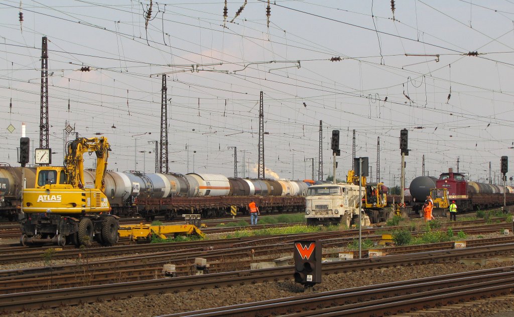 Ein Atlas 1304K der Gleisbau Weimar hat einen mit Kalk beladenen L60 der BZH GmbH, zu einer Gleisbaustelle in Grokorbetha gebracht. Jetzt fhrt er auf seinen eigenen Rdern auf dem zuknftigen neuen Gleisbett zur richtigen Stelle, um den Kalk fr den Unterbau zu entladen; 26.08.2011
