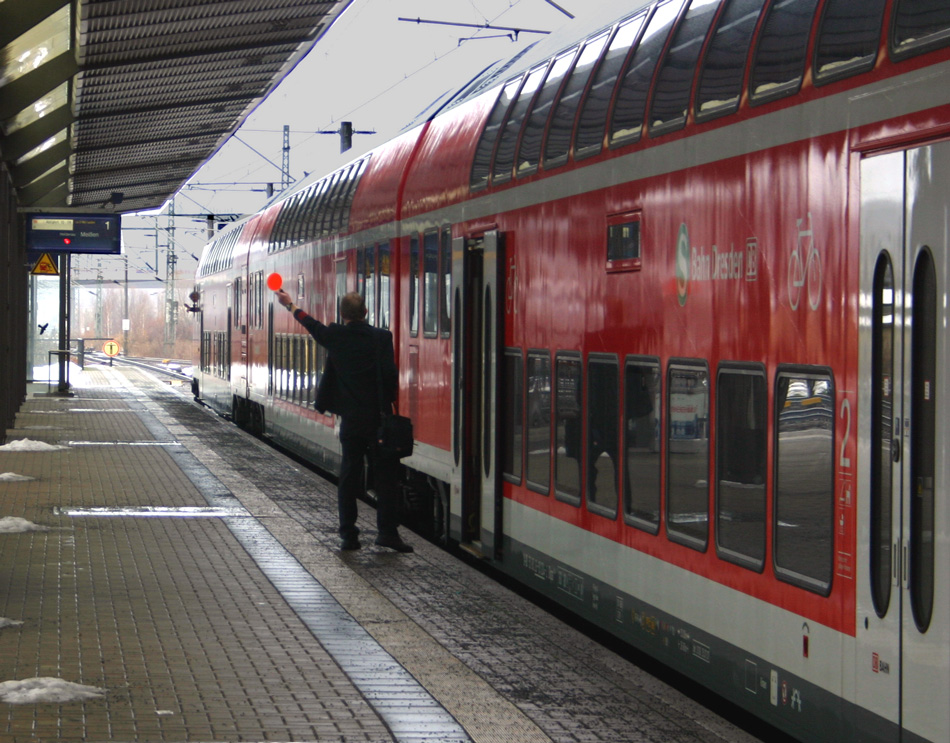 Ein bisschen Eisenbahnromantik bei der S-Bahn Dresden! Da Tren des Zuges der S1 nicht von den Loks (145er) aus geschlossen werden knnen, macht dies der  Schaffner  und gibt dessen erfolgreichen Abschlu mittels Pfeiffe und Kelle dem Kutscher kund. Da die 182er wohl erst Oktober 2011 der S1 zur Verfgung stehen werden, hat das betreffende Personal sicher noch viel Frischluft bei der Arbeit! Hier im Bild ist die S1 nach Meien im Bahnhof Pirna; 12.12.2010