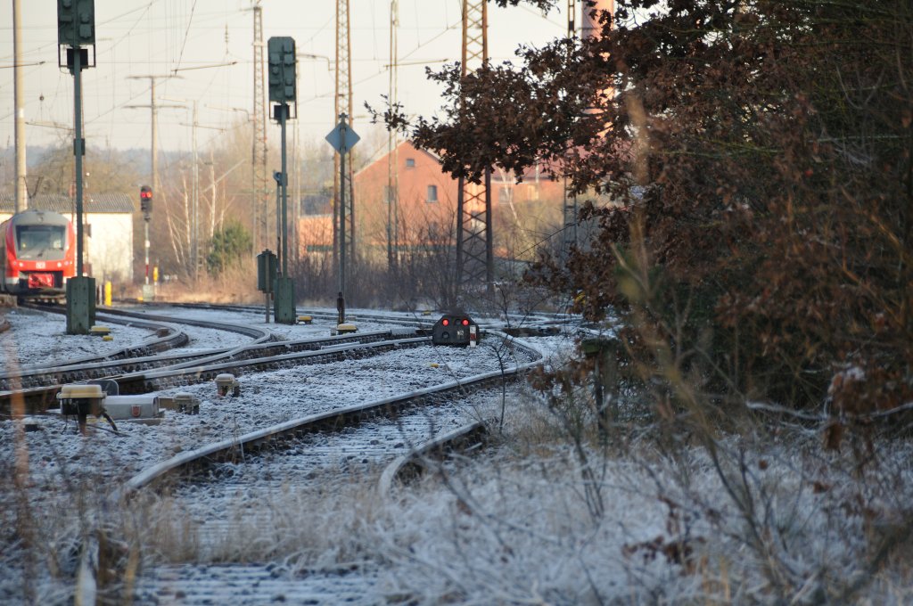 Ein Blick auf das stillgelegte Gleis direkt vor dem Bahnhof Neustadt Aisch. Im Hintergrund befinden sich Lichtsignale und ein Regionalzug.