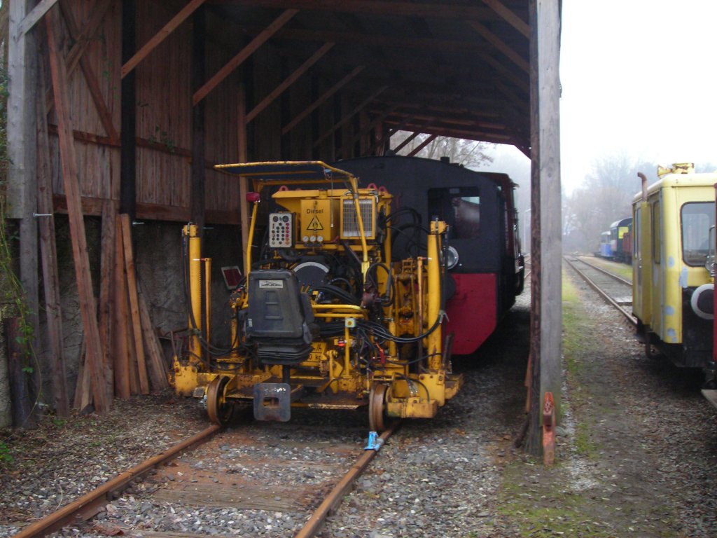 Ein Blick in den Schuppen. Im Vordergrund sieht man die Gleisstopfmaschine. Dahinter Die Kf und die 2060.14.
