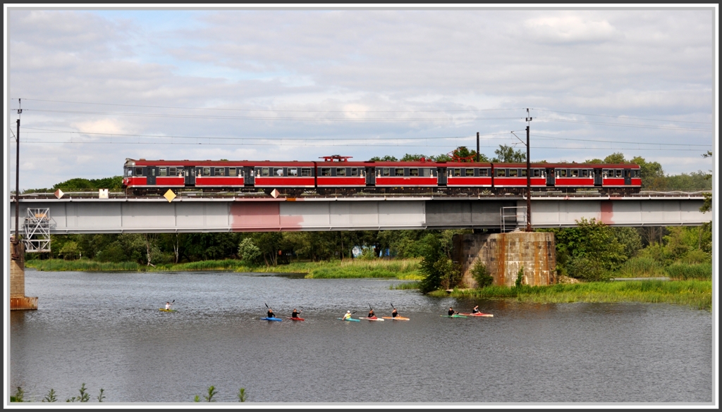 Ein EN57 berquert bei Malbork/Marienburg den Fluss Nogat, wo Kanuten ihrem Hobby nachgehen. (06.06.2012)