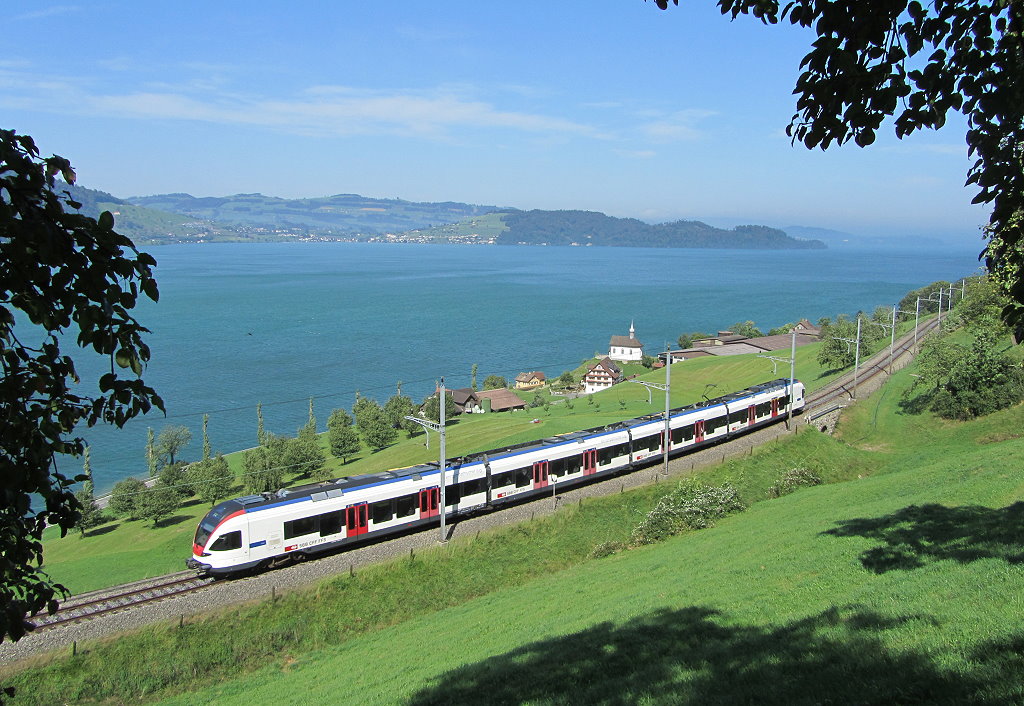 Ein Flirt Baureihe 523 ist zwischen Zug und Arth Goldau entlang des Zuger Sees unterwegs, 25.08.2011.