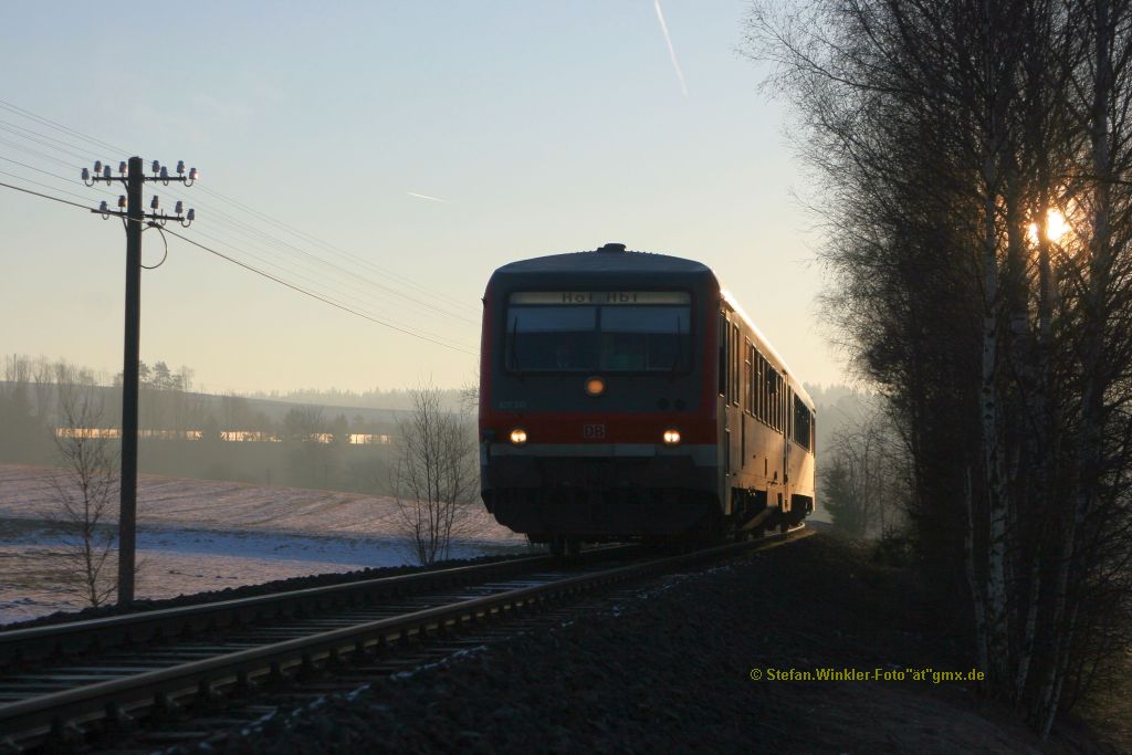 Ein Foto mit den ersten Sonnenstrahlen hinter Rehau, wo noch Telegrafenleitung an der ehemaligen Hauptstrecke existiert. 628 249 kommt am 25.02.2011 aus Selb herein und in 2-3 Minuten in Rehau halten.