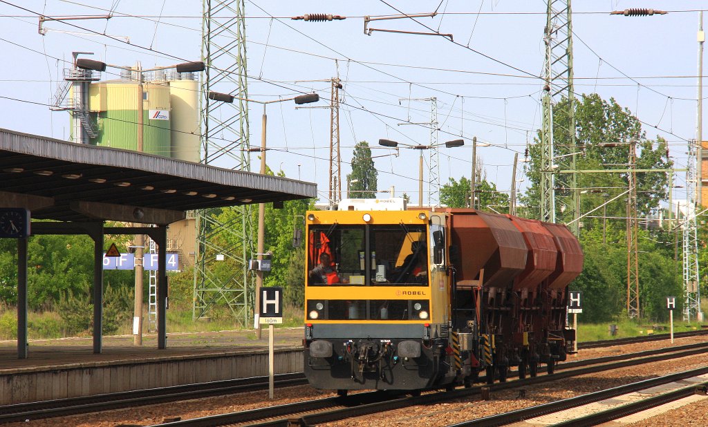 Ein Gleisarbeitsfahrzeug kommt mit drei Kohlewagen bei der durchfahrt Berlin-Flughafen-Sch�nefeld  und f�hrt in Richtung Potsdam bei Sonnenschein am 18.5.2012. 