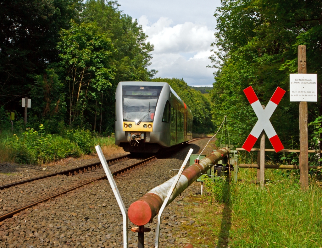 Ein GTW 2/6 der Hellertalbahn als (Neunkirchen-Herdorf-Betzdorf) fhrt am 30.07.2012 von Herdorf Richtung Betzdorf, hier beim B bei km 87,8 (Herdorf-Sassenroth). Bei diesem Bahnbergang wird die Schranke nur auf Verlangen geffnet. Wobei sie Mo. bis Fr. von 20:00 bis 5:00 und Sa. 14:00 bis Mo. 5:00 geschlossen bleibt.