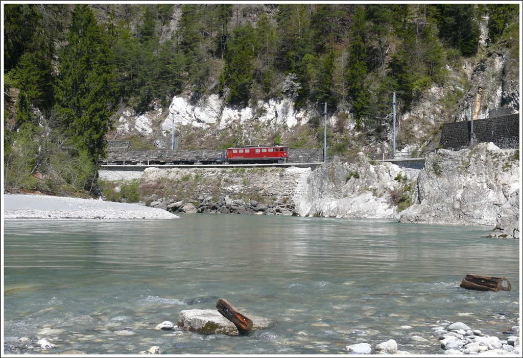 Ein Gterzug aus Disentis mit Ge 6/6 II 707  Scuol  erscheint bei der Hochwassermarke. Im Schlepptau hat er unter anderem eine Garnitur Langschienentransportwagen der MGB. (28.04.2010)