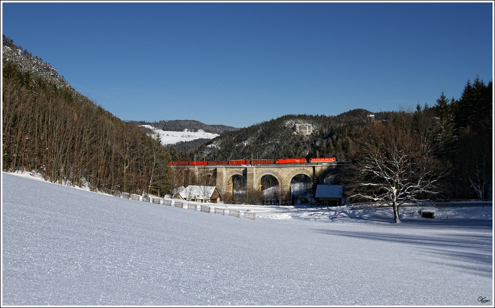 Ein Gterzug, bespannt mit einer 1144 und einer 1116, berquert das 151 m lange   Adlitzgraben-Viadukt nahe Semmering. 
17.01.2012