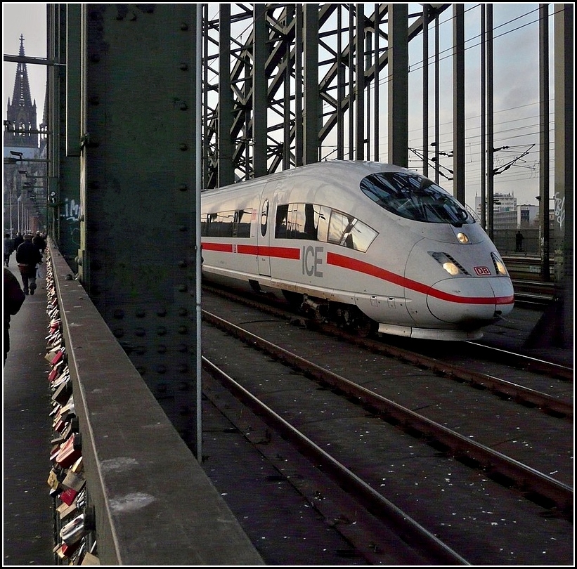 Ein ICE 3 fhrt am Abend des 20.11.2010 ber die Hohenzollernbrcke in Kln, vorbei an den Unmengen von Schlssern, die den Zaun schmcken. (Jeanny)  