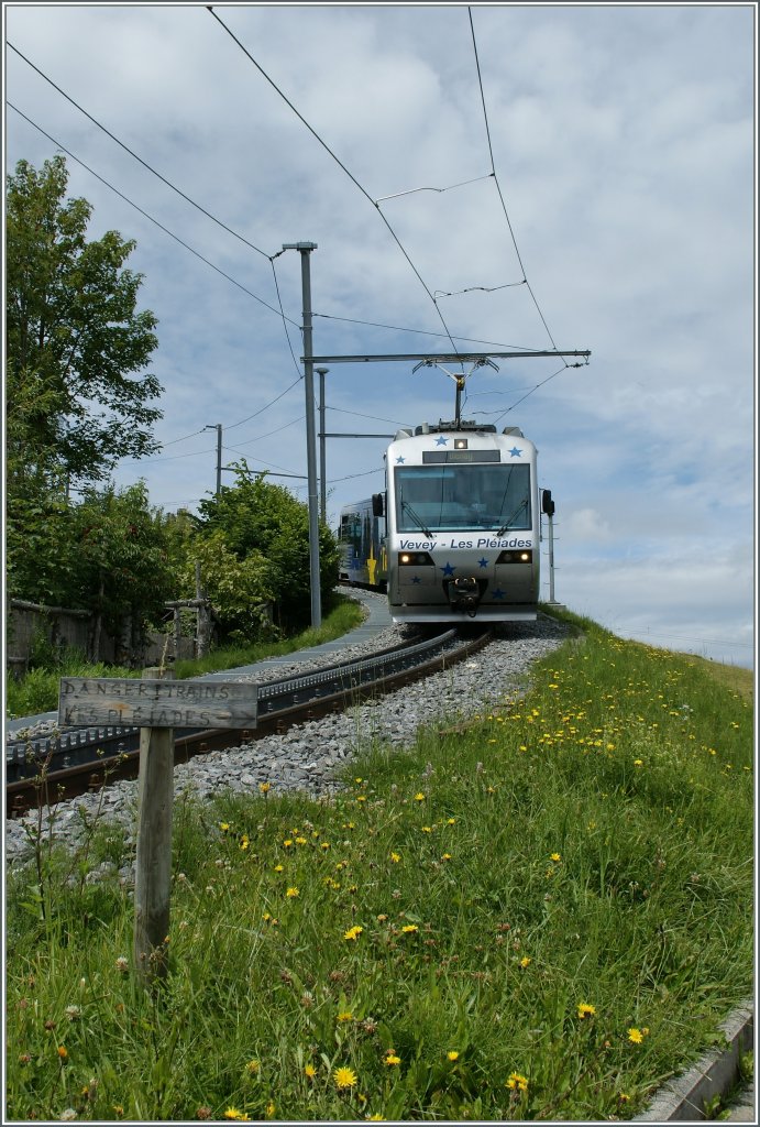 Ein kleines, wackliges Schild dirigiert die Wanderer auf den im Bild nur angedeutet Wanderweg Richtung Les Pléiades, und wenn man den Zug kommen sieht, zeigt sich eindeutig, dass auf dem Bahntrasse kein Platz für Wanderer ist...
Bei Lally, am 26. Juli 2011