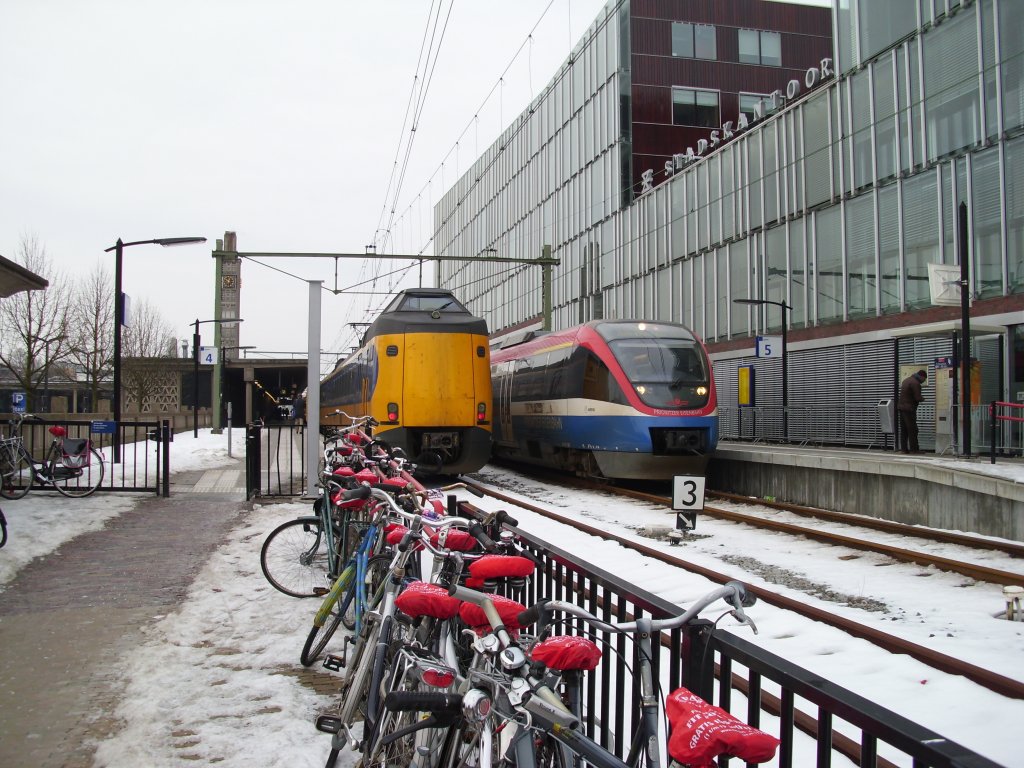 Ein Koploper und ein Talent in Enschede der rechte Zug fhrt nach Dortmund und der linke nach Den Haag und Rotterdam. Im Vordergrund seht man das vermutlich belipteste Verkrsmittel der Niederlnder :-)