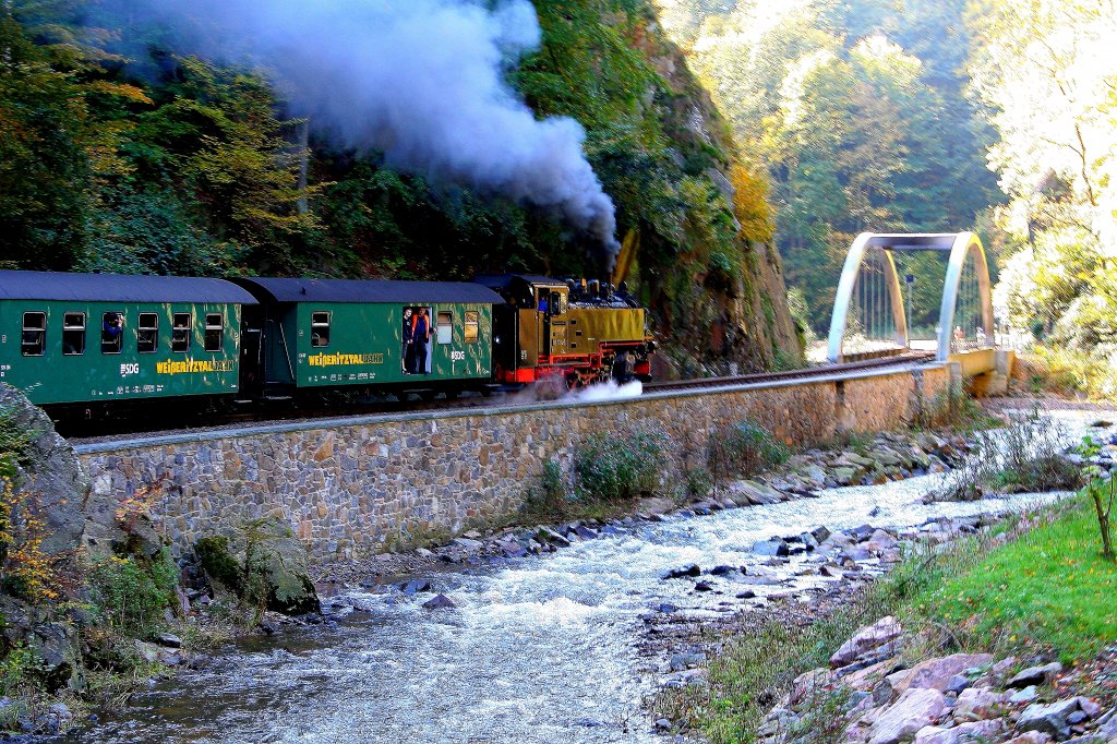 Ein Planzug der Weieritztalbahn hat am 09.10.2010 soeben den Bahnhof Rabenau in Richtung Malter, Dippoldiswalde verlassen und wird gleich die neue Bogenbrcke ber die Weieritz im Rabenauer Grund berqueren.