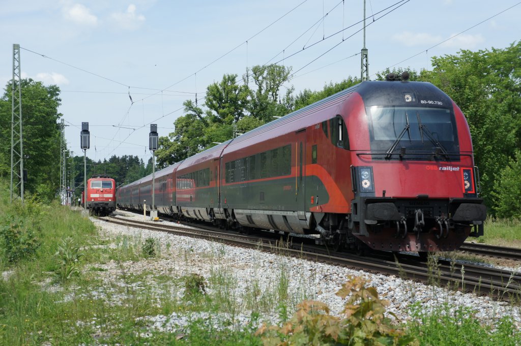 Ein Railjet berholt 111 043-6 mit ihrem RE nach Salzburg im Bahnhof Aling am 31.05.11.