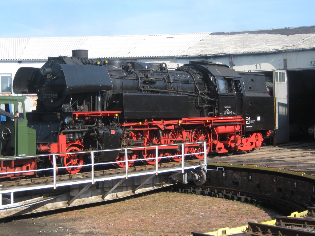 Ein Rangiertraktor zieht die BR65 1049 der DR ins Sonnenleicht auf der Drehscheibe des BW Arnstadt historisch in Th�ringen.
Anl�sslich des Dampfloktages am 16.09.2012 wurden nacheinander verschiedenste Fahrzeuge dem Publikum pr�sentiert. Besuch, absolut empfehlenswert !