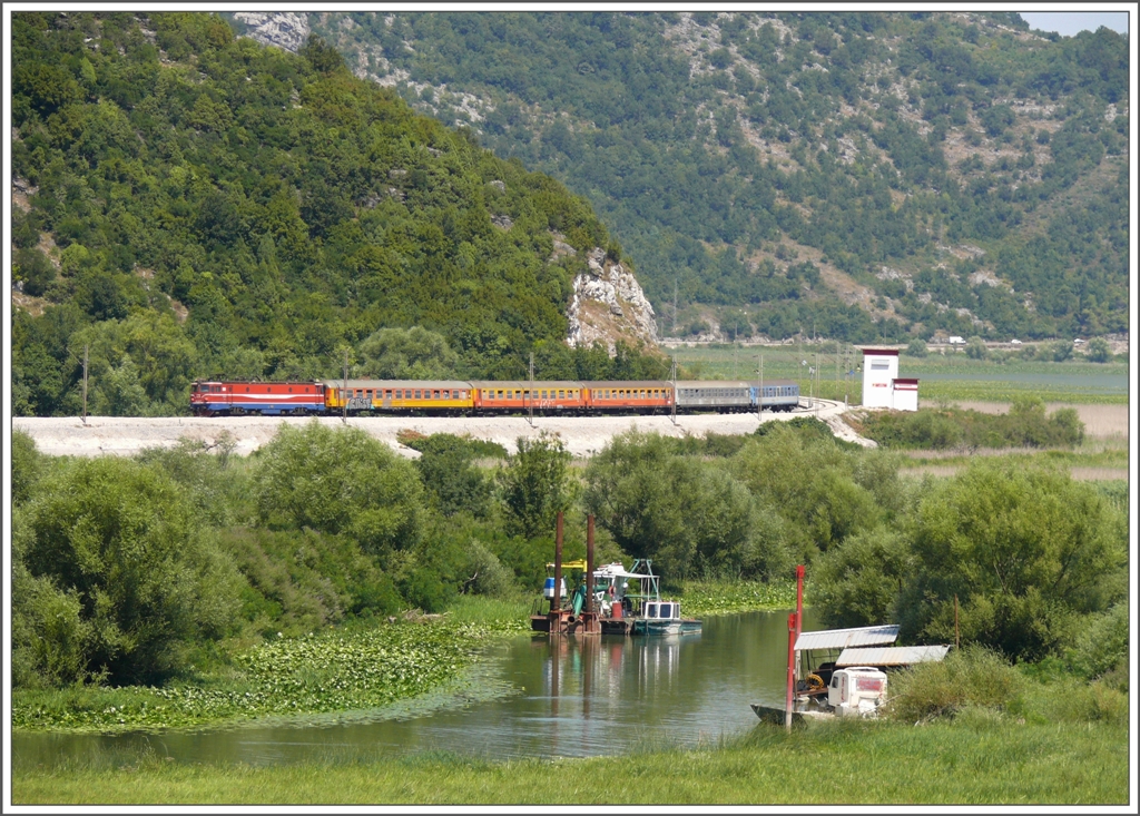 Ein Schnellzug nach Bar kommt bei Virpazar um die Kurve. Das Gewsser im Vordergrund dient den Ausflugsschiffen ab Virpazar als Zufahrt zum Skadarsko Jezero/Skutarisee. (08.08.2010)