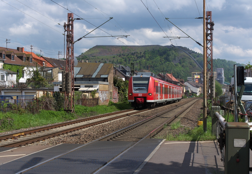 Ein sonniger Tag in der Stadt des Sonnenknigs - 

Saarlouis (Sarre-Louis) ist eine Grndung des Sonnenknigs Ludwig XIV.

Vielleicht scheint deswegen die Sonne hier etwas mehr als in anderen Stdten.

Zwischen Saarbrcken und Merzig gibt es an der KBS 685 nur noch zwei Bahnbergnge. Beide befinden sich im Bereich der Stadt Saarlouis. Einer als Anrufschranke im Bereich der Signalbrcke in Roden und der zweite hier in Fraulautern bei der Zufahrt zur Verzinkerei Becker.

425 136-9 kommt aus Richtung Ensdorf. Im Hintergrund ist die Halde des Bergwerk Saar zu sehen, welches Ende April 2012 die Frderung eingestellt hat.

Noch etwas mehr als 1 Km sind es bis zum Hauptbahnhof Saarlouis.

03.05.2012