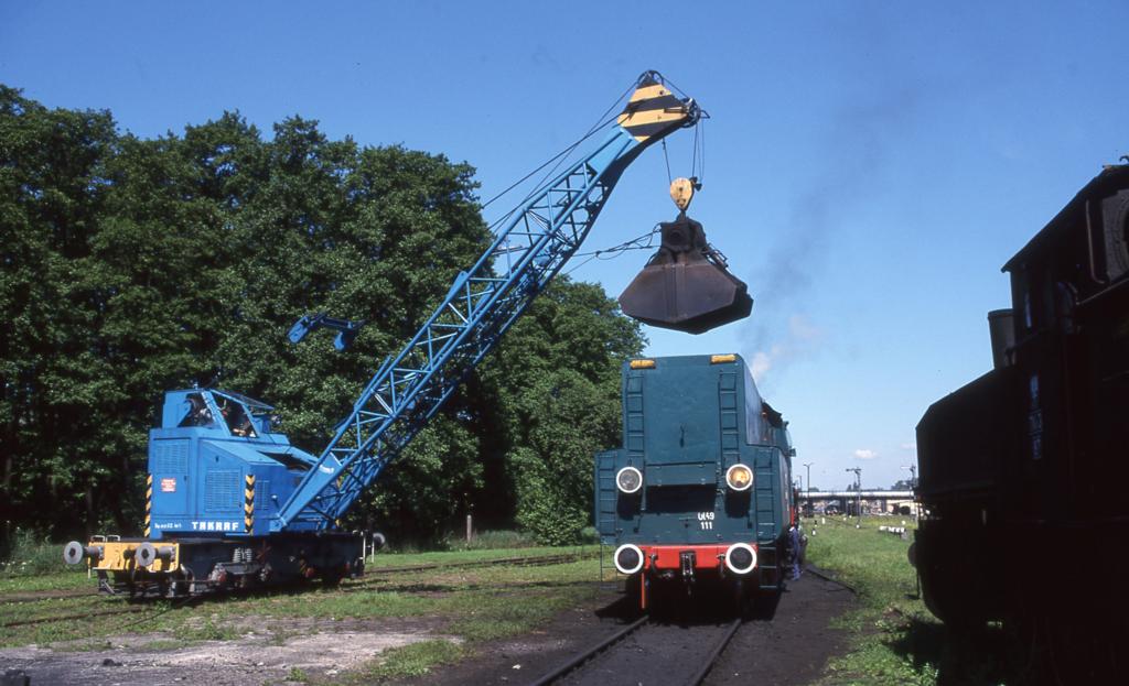 Ein TAKRAF Schienenbagger noch aus DDR Zeiten und Produktion 
beldt die PKP Ol 49-111 mit Kohle. Die Szene wurde von mir 
am 2.6.2000 im Bahnbetriebswerk Wosztyn aufgenommen.
