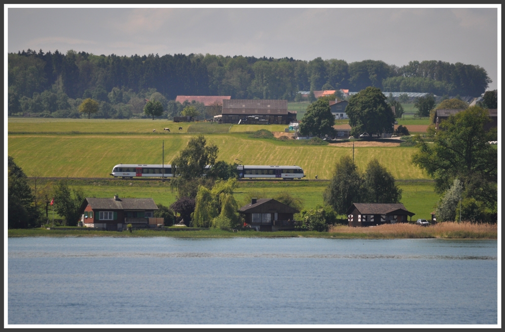 Ein Thurbo GTW zwischen Romanshorn und Kreuzlingen, aufgenommen von einem Bodenseeschiff. (20.05.2012)