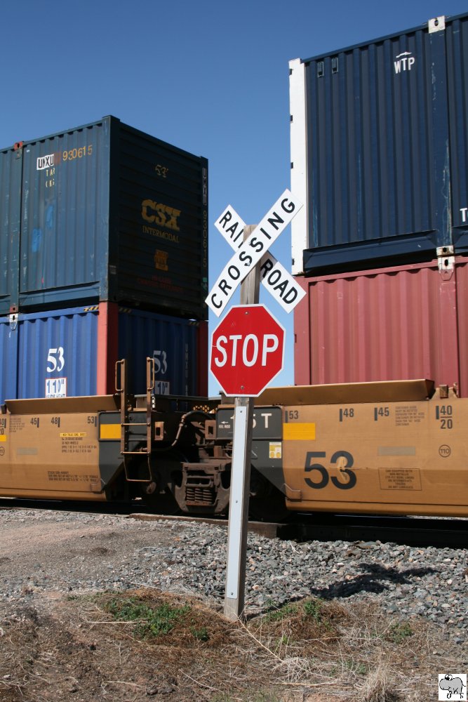 Ein unbeschrankter Bahnbergang in New Mexico wird von einem Containerzug passiert.