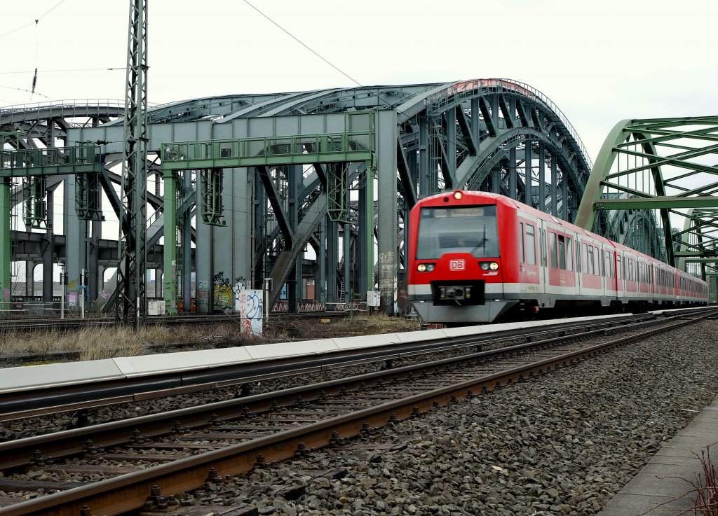 Ein Zug der Hamburger S-Bahn-Linie S3 hat gerade die Norderelbbrcken berquert - auf seinem Weg nach  Neugraben . Fotografiert vom Veddeler Elbdeich, 14.4.2013