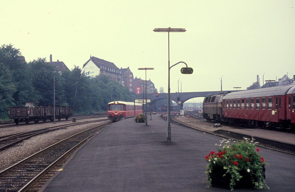 Ein Zug der HHJ, Hads Ning Herreders Jernbane (Odderbanen), kommt am 13. September 1974 in Århus H (: Aarhus Hauptbanhnhof) an. Diese Bahn bediente damals die Bahnstrecke Århus / Aarhus - Odder - Hov. - Rechts im Bild ist eine Diesellok der Baureihe Mz mit IC-Personenwagen zu sehen.