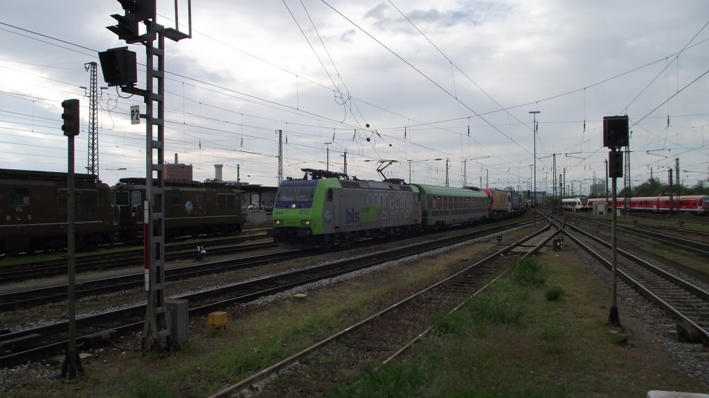 Ein Zug der Rollenden Landstrasse des Betreibers  RALPIN  mit Re 485 012 aus Freiburg kommend bei der Durchfahrt Basel Badischer Bahnhof.
Im Hintergrund zwei Loks der Baureihe Re 4/4 der BLS, 08.05.13.